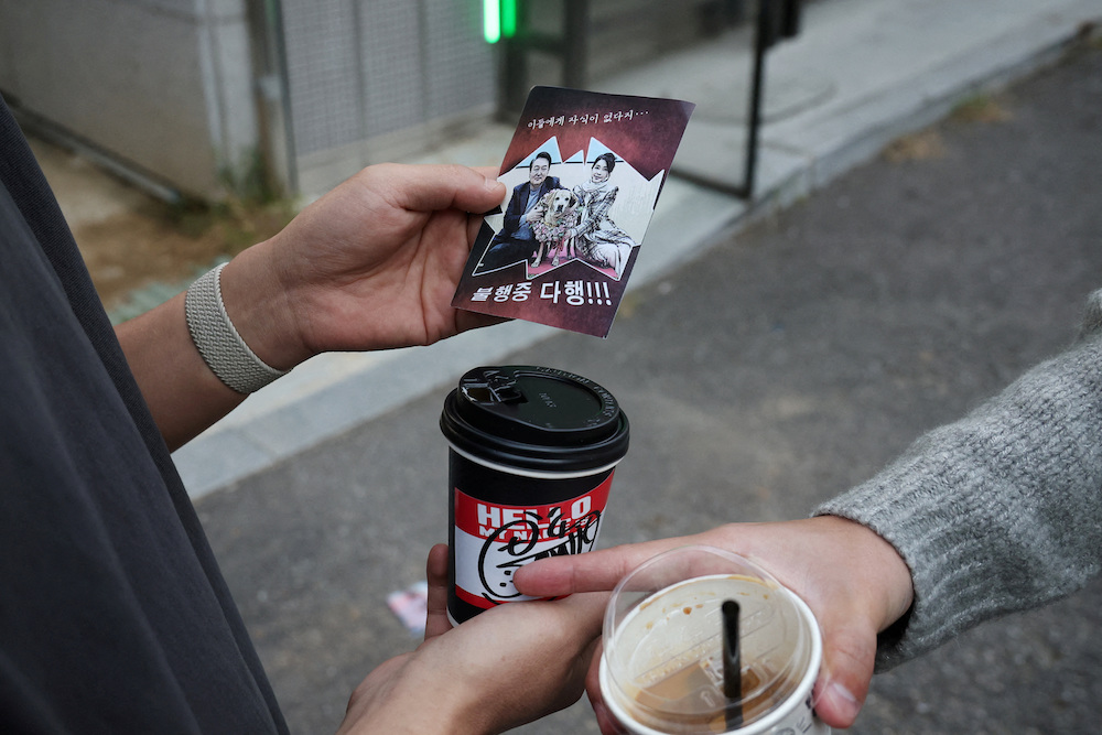 People look at a North Korean propaganda leaflet denouncing South Korean President Yoon Suk Yeol and his wife Kim Keon Hee on Oct. 24, 2024. (Reuters)