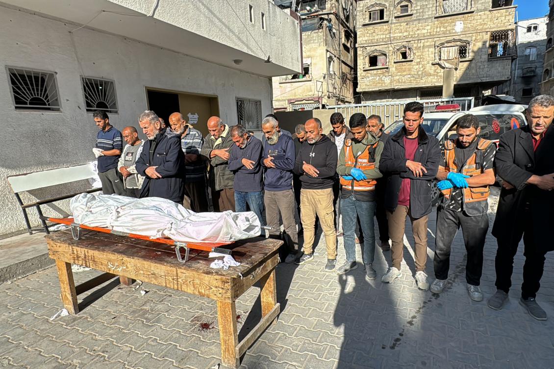 Palestinians pray by the body of victim of Israeli bombardment of the Beit Lahia Project area in the northern Gaza Strip on Oct. 23, 2024. (AFP)