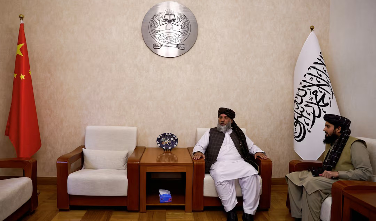 Taliban's acting commerce minister Haji Nooruddin Azizi sits next to flags of the Islamic Emirate of Afghanistan and China, during an interview with Reuters, at the Embassy of Afghanistan in Beijing, China on October 19, 2023. (REUTERS/File)