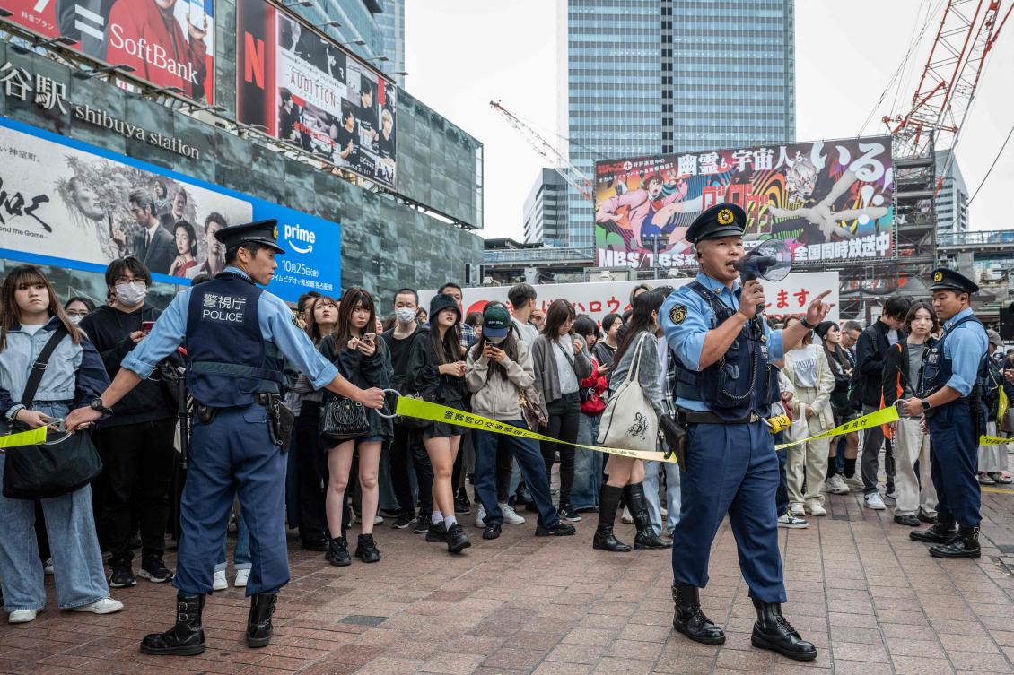 Police officers regulate pedestrians before an election campaign speech by Yoshihiko Noda, leader of the Constitutional Democratic Party, in front of Shibuya station in Tokyo on Oct. 26, 2024. (AFP)