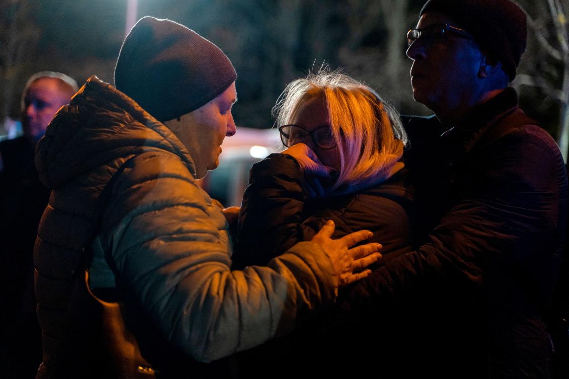 Residents comfort each other near the site where a Russian drone struck a high-rise residential building in Kyiv's western Solomianskyi district on October 25, 2024, amid the Russian invasion of Ukraine. (AFP)