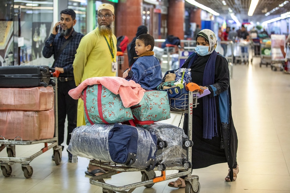 A Bangladeshi national carries luggage upon her arrival from Lebanon at the Hazrat Shahjalal International Airport in Dhaka on Oct. 21, 2024. (AFP)