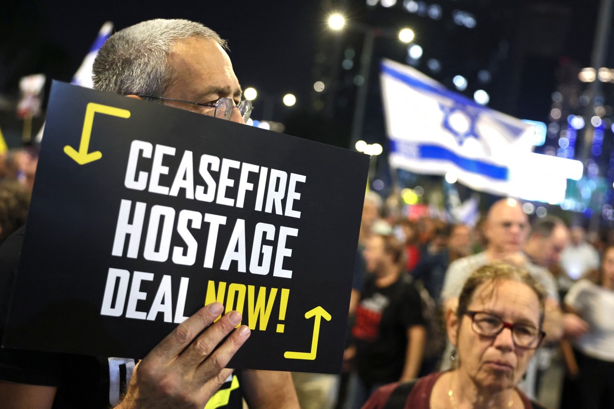Demonstrators raise placards and Israeli flags during an anti-government protest calling for action to secure the release of Israeli hostages held captive since the October 7 attacks by Palestinian militants in the Gaza Strip, in front of the Israeli Defence Ministry in Tel Aviv on October 26, 2024. (File/AFP)