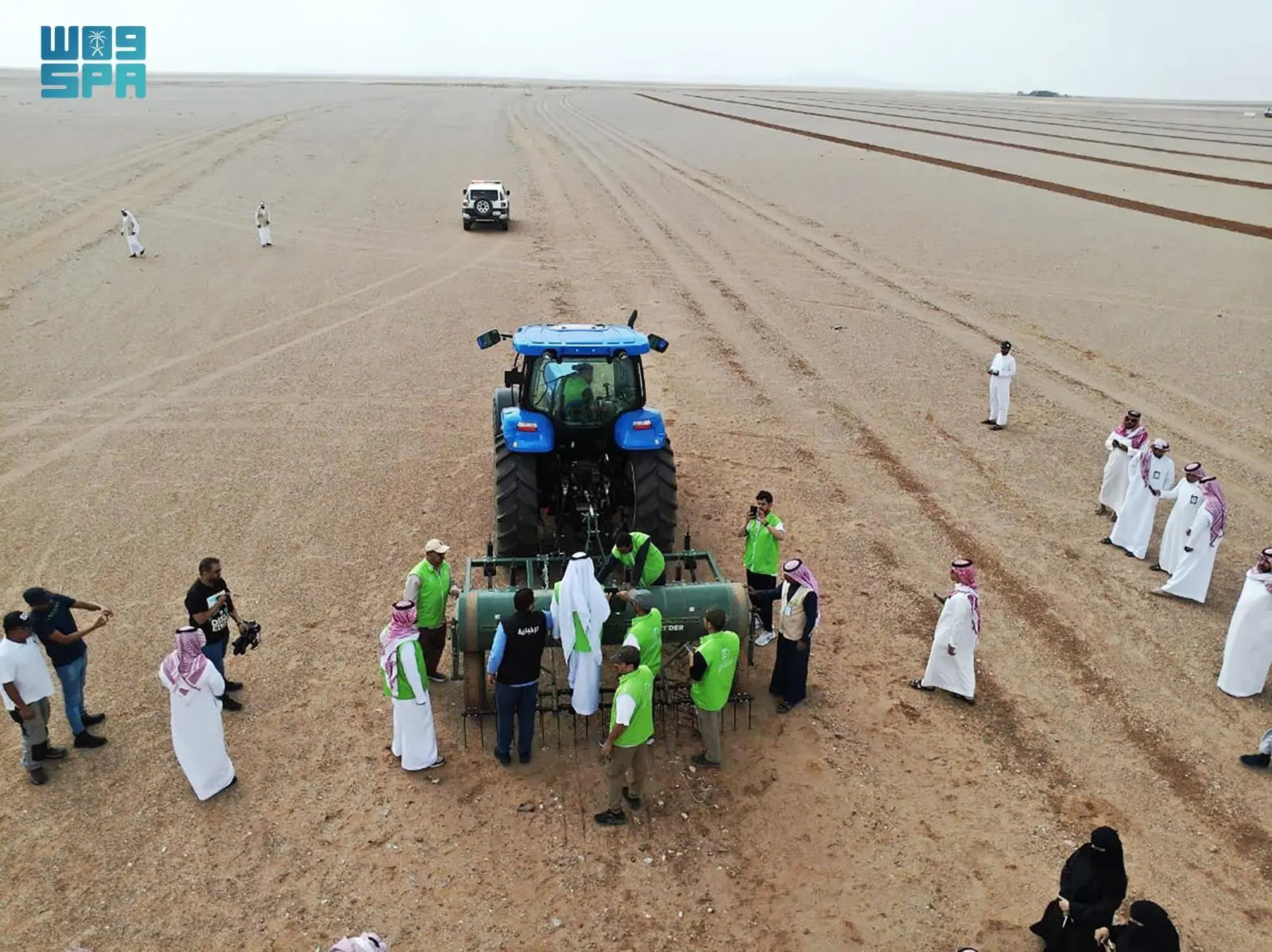 Officials and representatives of government entities and associations along with locals participate in the greening activity at the King Abdulaziz Protected Pasture in Al Hanakiyah governorate. (SPA photo)
