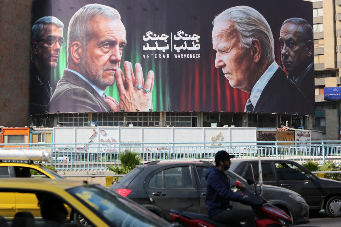 Commuters drive past a billboard bearing pictures of Iran’s President Masoud Pezeshkian (2-L), armed forces chief of staff Major General Mohammad Bagheri (L) US President Joe Biden (2-R) and Israeli Prime Minister Benjamin Netanyahu (R) in Vali-Asr square in Tehran on October 27, 2024. (AFP)