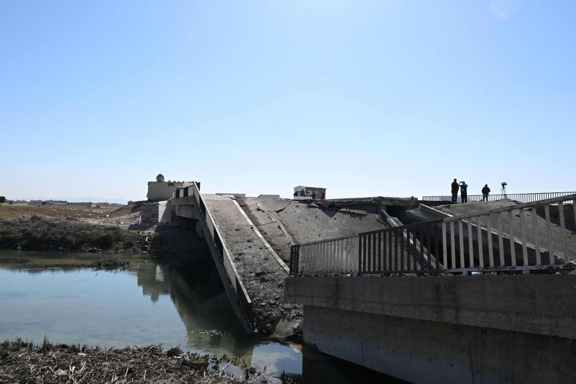 People inspect a bridge, damaged in an Israeli strike near the Syrian village of Tall Al-Nabi Mando, in the countryside of Qusayr on October 28, 2024. (AFP)