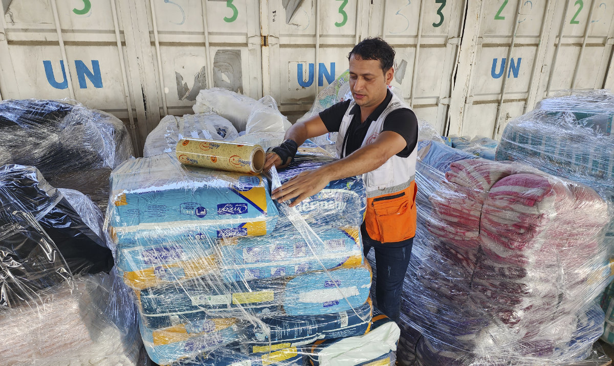 United Nations and Red Crescent workers prepare the aid for distribution to Palestinians at UNRWA warehouse in Deir Al-Balah, Gaza Strip. (AP/File)