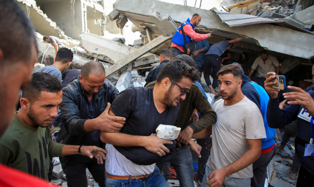 A Palestinian man is assisted at the site of an Israeli strike on a house, amid the ongoing Israel-Hamas conflict, in Gaza City, October 26, 2024. (Reuters)