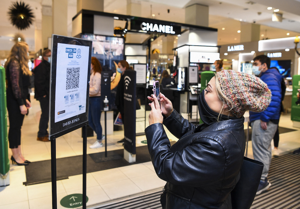 Although Australia’s COVID-19 response was largely successful, the inquiry found that restrictive measures and other blunders fueled mistrust in scientists and public health officials. Above, a woman scans a QR code to enter a department store in Melbourne on Oct. 29, 2021. (AFP)