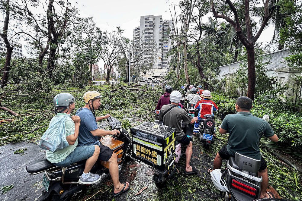 The southern Chinese province of Hainan has been half-submerged in a year of record-breaking wet weather. Residents ride fallen trees after Super Typhoon Yagi hit Haikou in Hainan on Sept. 7, 2024. (AFP file photo)