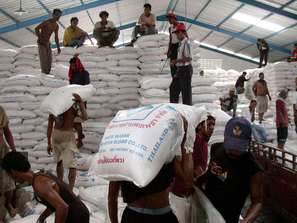 Indonesian workers unload imported sugar from a truck in Semarang, April 27, 2004. Local farmers long expressed concerns over a massive influx of less expensive imported sugar, which they alleged was being smuggled into the country. (AFP file photo)