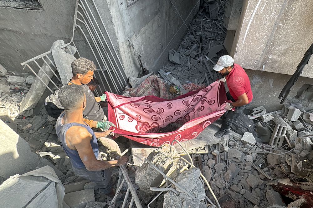 Palestinians remove a body from the rubble of a building hit by an Israeli strike in Beit Lahia in the northern Gaza Strip on Oct. 29, 2024. (AFP)