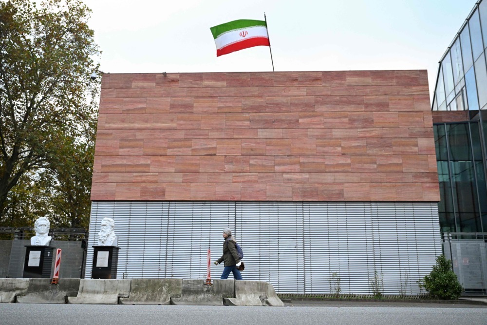 A woman walks past the Consulate General of the Islamic Republic of Iran with Iran's national flag flying atop the building in Frankfurt am Main, western Germany. (AFP)