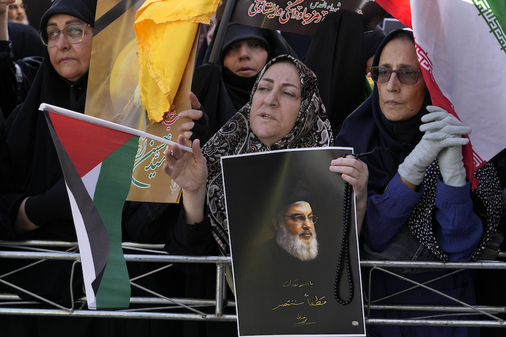 An Iranian demonstrator holds a poster of slain Hezbollah leader Hassan Nasrallah. (AP)