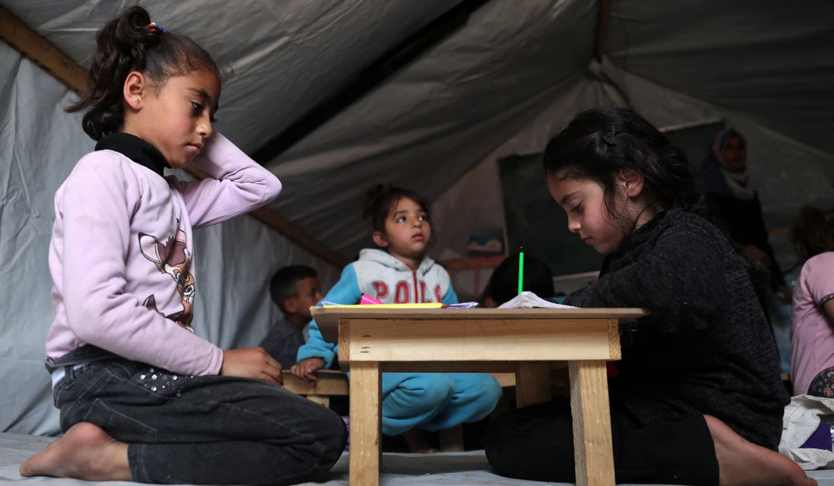 Children attend class at a makeshift classroom in a camp for displaced Palestinians in Rafah, in the southern Gaza Strip. (AFP)