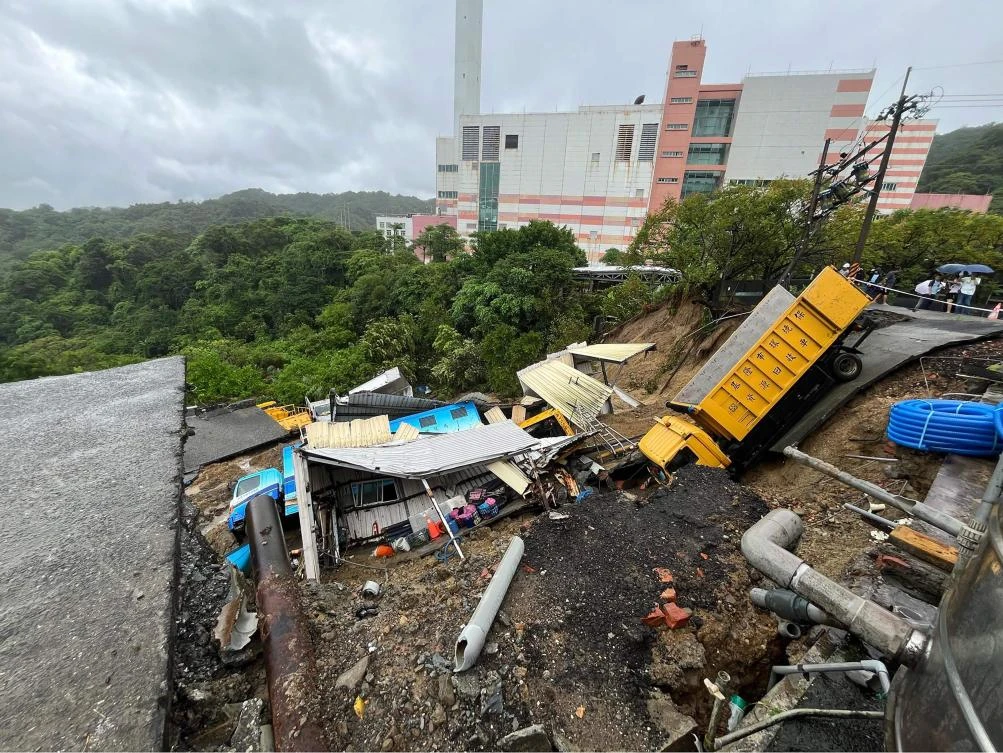 Above, public utility vehicles are trapped in a landslide near Keelung City’s Bureau of Environmental Protection, which was triggered by heavy rainfall after Typhoon Krathon swept across the island. (Taiwanese city councilor Chen Yi via AFP)