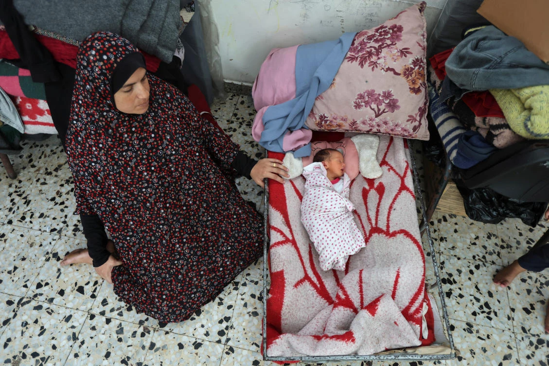 Palestinian mother Manar Abu Jarad sits next to her daughter Sahar inside a school sheltering displaced people in Deir Al-Balah, Sept. 9, 2024. (Reuters)