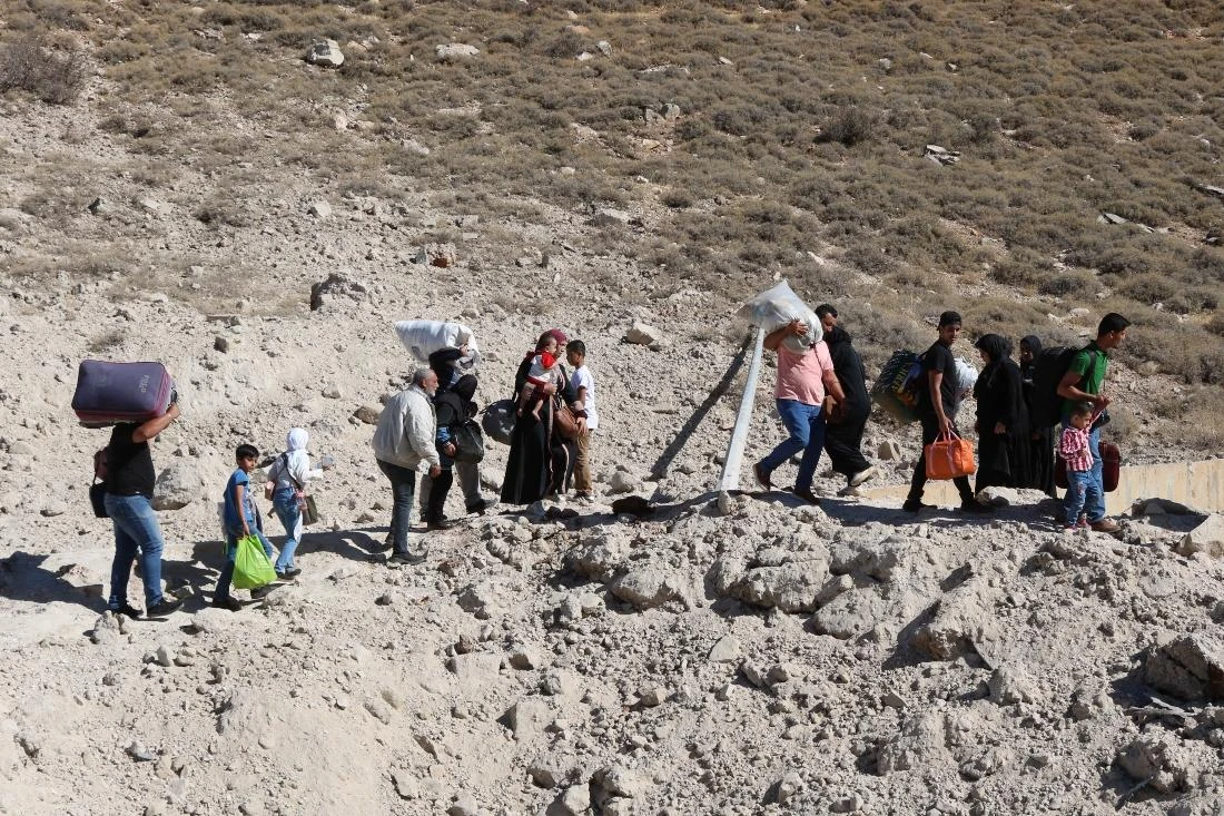 On Friday, an AFP photographer saw people carrying bags and children as they walked around a crater where a strike had hit. (AFP)