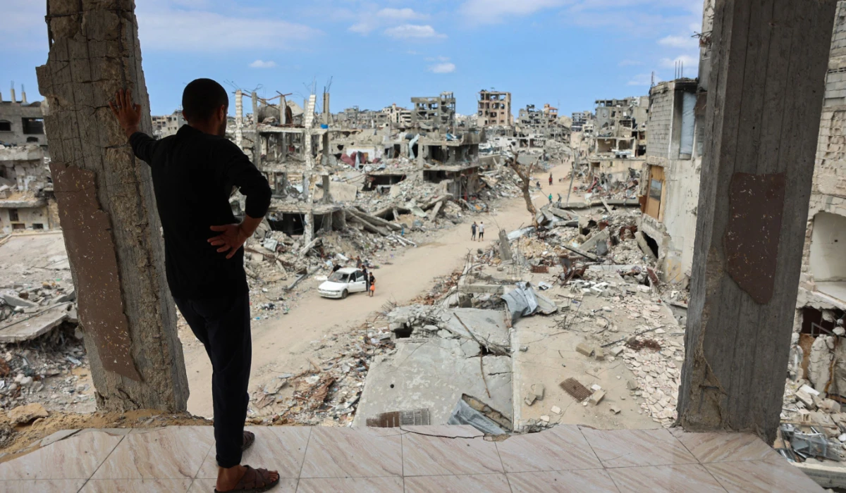 A Palestinian man looks from a damaged building at a dirt road lined with rubble in the Shujaiya neighbourhood of Gaza City on October 7, 2024, on the first anniversary of the ongoing war in the Gaza Strip between Israel and the Palestinian Hamas group. (AFP)