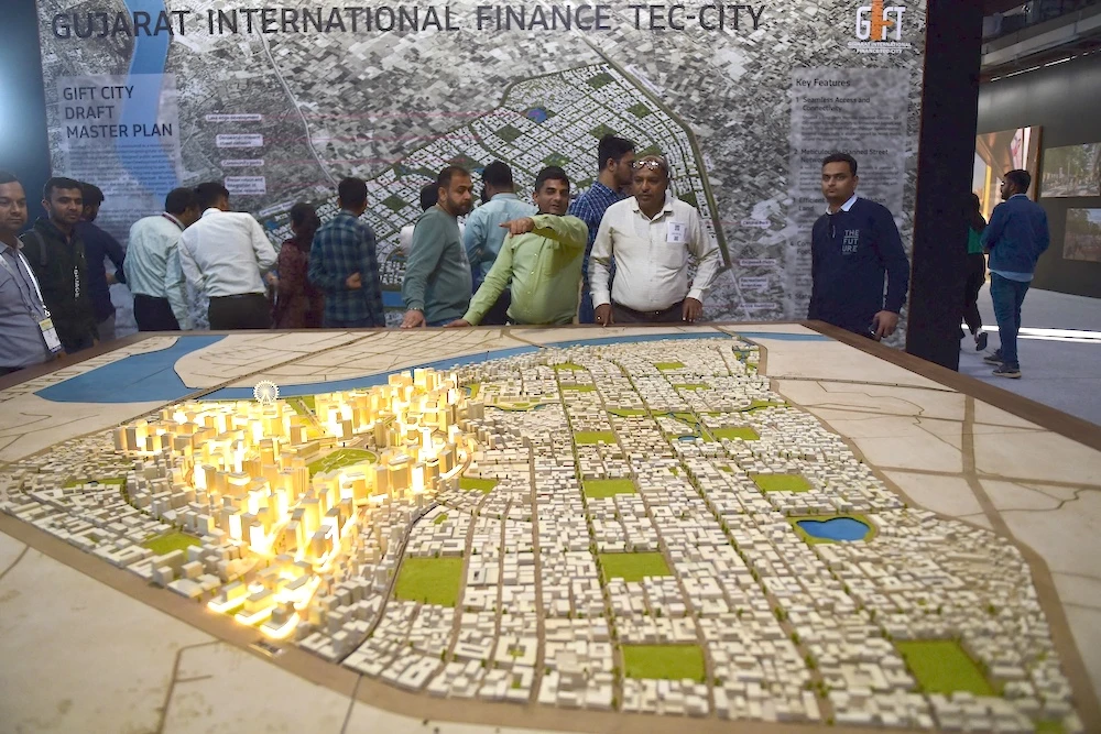 Above, people visit the Gujarat International Finance Tec-City pavilion at the Vibrant Gujarat Trade Show in Gandhinagar on Jan. 11, 2024. (AFP)