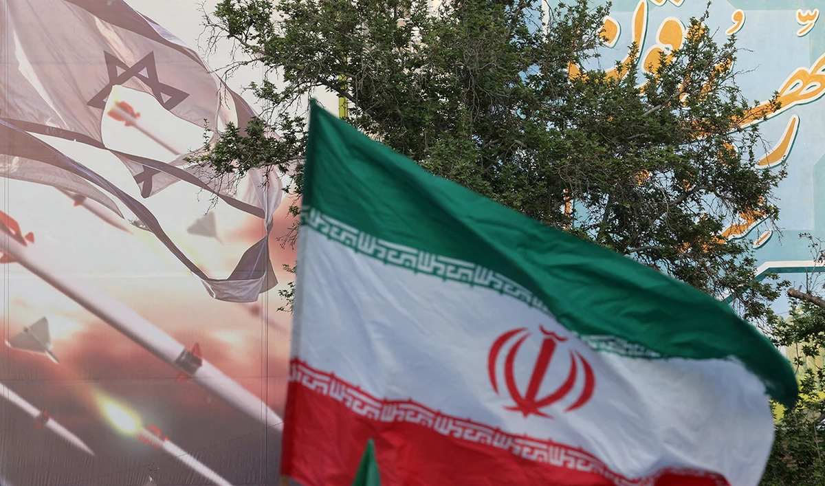 An anti-Israel billboard is seen next to the Iranian flag during a celebration following the IRGC attack on Israel, in Tehran, Iran, April 15, 2024. (REUTERS/File)