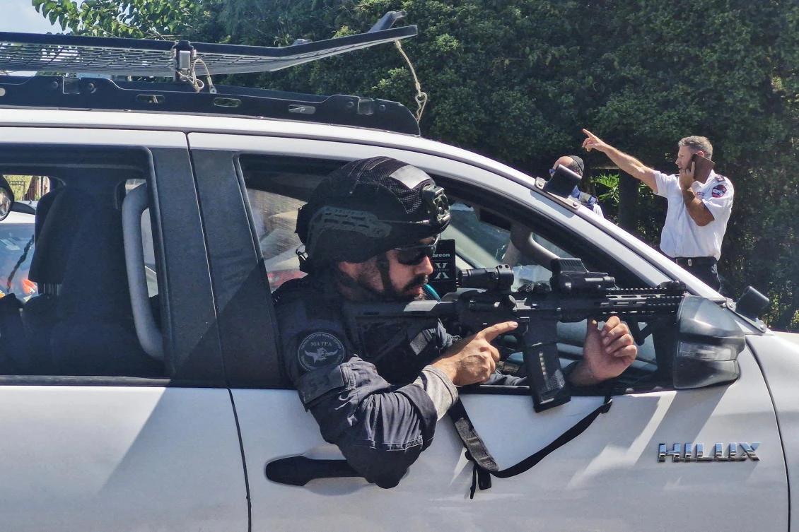 An Israeli police officer aims his weapon from a vehicle following a suspected stabbing attack in Hadera, Israel, on Oct. 9, 2024. (Reuters)