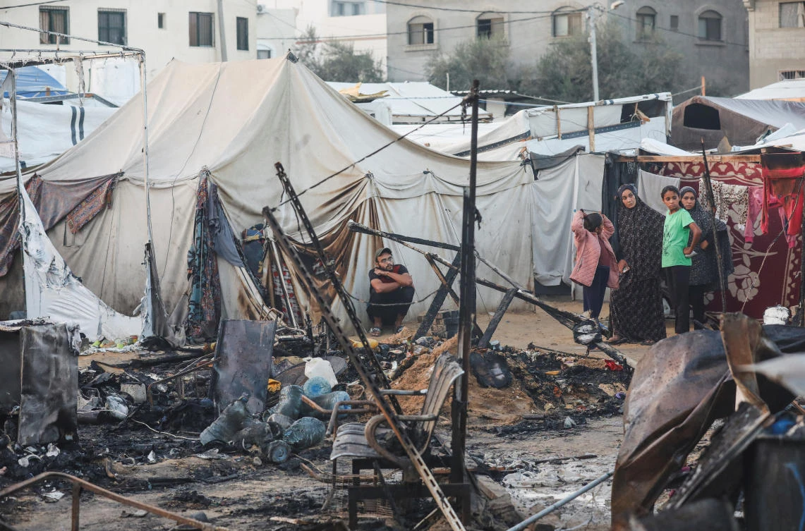 Palestinians survery the damage at the site of an Israeli strike on tents sheltering displaced people, amid the Israel-Hamas conflict, at Al-Aqsa Martyrs hospital in Deir Al-Balah in the central Gaza Strip. (REUTERS)