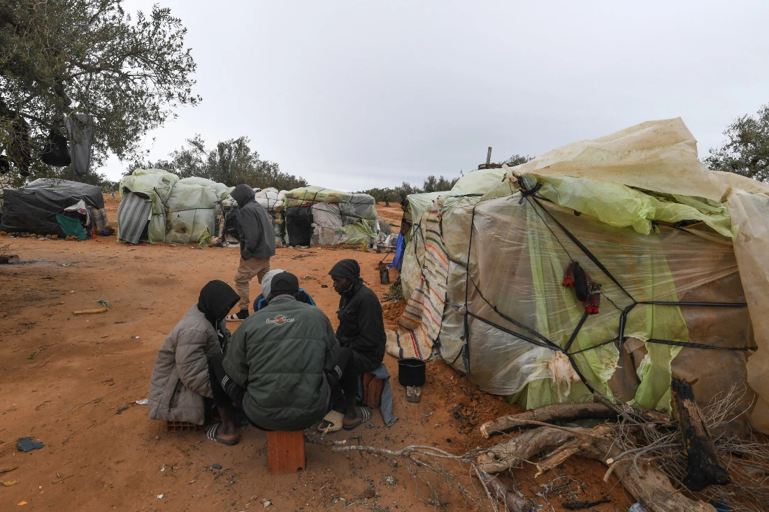 Migrants from Sub-Saharian Africa sit near tents at a camp in Jebeniana in Tunisia's Sfax governorate. (File/AFP)