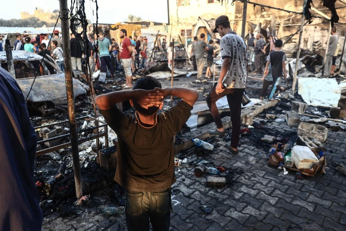 A Palestinian boy gestures as people check the destruction following an Israeli army strike around tents for displaced people inside the walls of Al-Aqsa Martyrs Hospital in Deir Al-Balah on Oct. 14, 2024. (AFP)