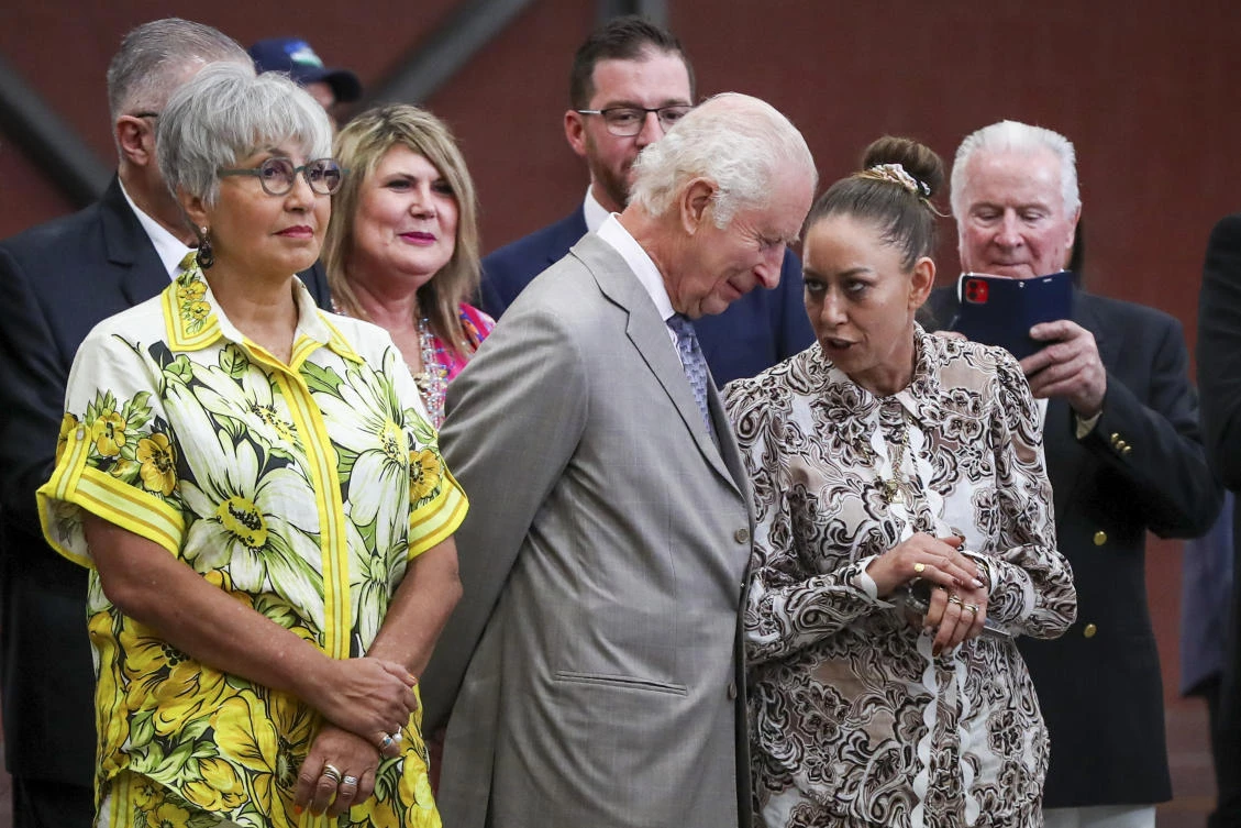 Britain's King Charles III, center, stands with Jody Broun, left, CEO National Indigenous Australians Agency, while watching a traditional performance during a visit to the National Centre of Indigenous Excellence in Sydney, Australia. (AP)