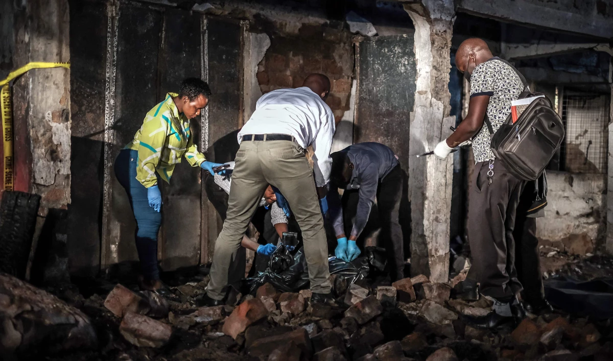 Forensic specialists and emergency responders seal a body bag containing a deceased person after a fuel truck explosion in Kigogwa, on October 22, 2024. (AFP)