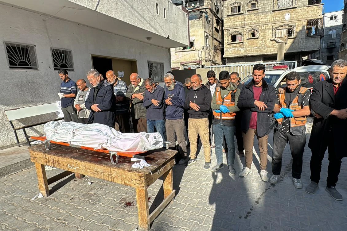 Palestinians pray by the body of victim of Israeli bombardment of the Beit Lahia Project area in the northern Gaza Strip on Oct. 23, 2024. (AFP)