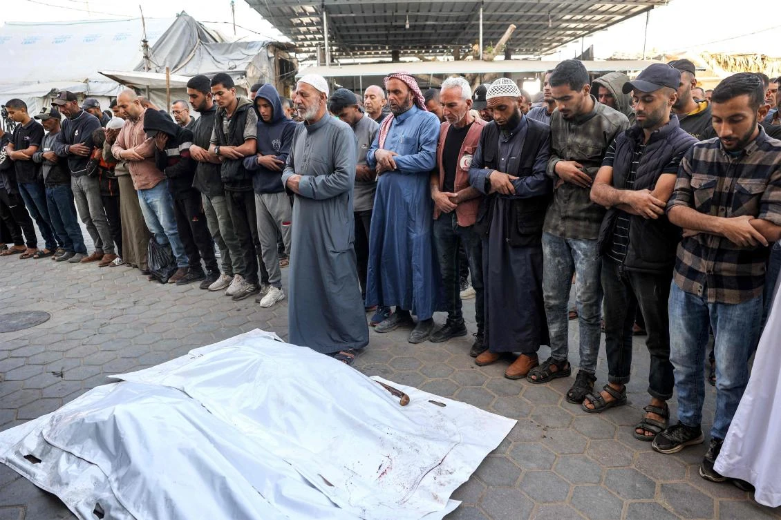 Mourners pray before the bodies of workers of UNRWA who were killed earlier when their truck was reportedly hit by bombardment, during the funeral at the Aqsa Martyrs’ Hospital in Deir el-Balah in Gaza on Oct. 23, 2024. (AFP)