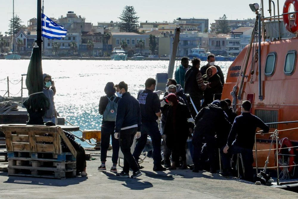 Migrants disembark a Hellenic Coast Guard vessel after being rescued at sea, on the island of Chios, Greece, October 26, 2021. (Reuters)