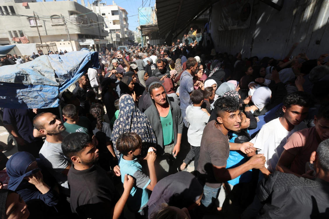 Palestinians gather to buy bread from a bakery, amid the Israel-Hamas conflict, in Deir Al-Balah in the central Gaza Strip Oct. 24, 2024. (Reuters)