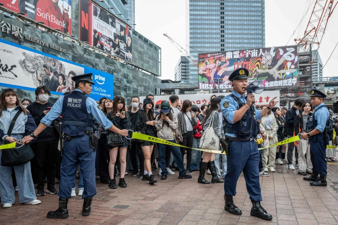 Police officers regulate pedestrians before an election campaign speech by Yoshihiko Noda, leader of the Constitutional Democratic Party, in front of Shibuya station in Tokyo on Oct. 26, 2024. (AFP)