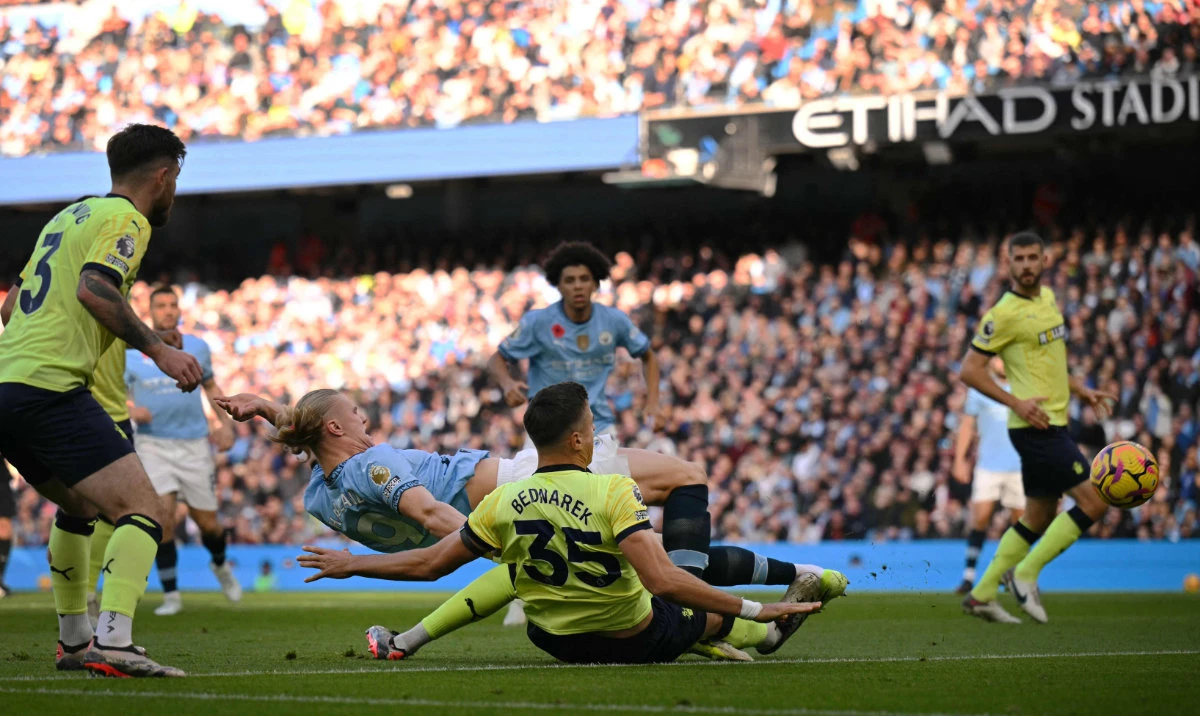 Manchester City's Norwegian striker Erling Haaland (2nd L) falls backward as he scores the opening goal during the English Premier League football match between Manchester City and Southampton at the Etihad Stadium in Manchester, north west England, on Oct. 26, 2024. (AFP)