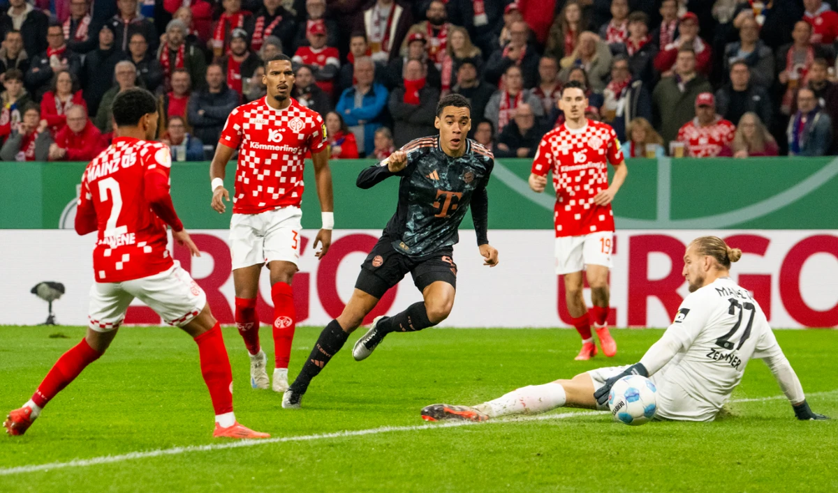 Bayern’s Jamal Musiala, center, scores past Mainz goalkeeper Robin Zentnerduring a second round German Cup soccer match between FSV Mainz 05 and Bayern Munich Wednesday in Mainz, Germany. (AP)