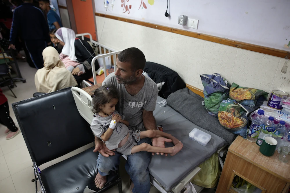 Abdulrahman Al-Rai holds his daughter Hana Al-Rai, 3, who suffers from diabetes, a weakened immune system and malnutrition. (AP)