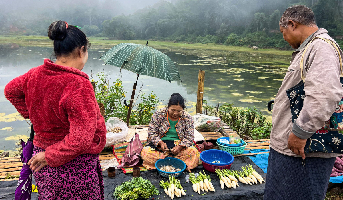 A vendor prepares vegetable to sell to customers at a street market in Taunggyi, Myanmar, on November 13, 2024. (AFP)