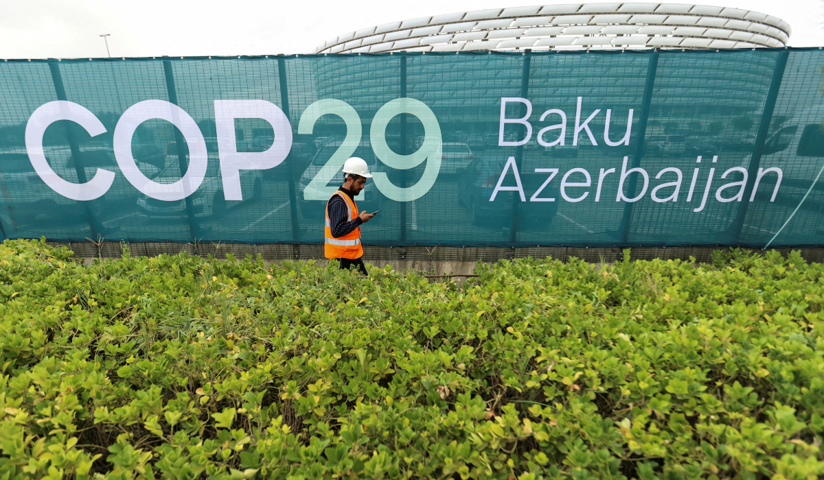 A worker walks along a fence near the Baku Olympic Stadium in Baku, Azerbaijan October 18, 2024. (REUTERS)