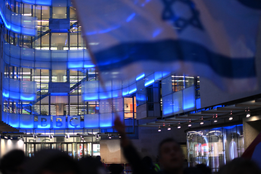 Above, protesters waving Israeli flags at the headquarters of the BBC in London on Oct. 16, 2023 call for the broadcaster to call Hamas ‘terrorists.’ More than 100 employees have accused BBC of pro-Israel bias in its coverage of the Gaza war. (AFP)