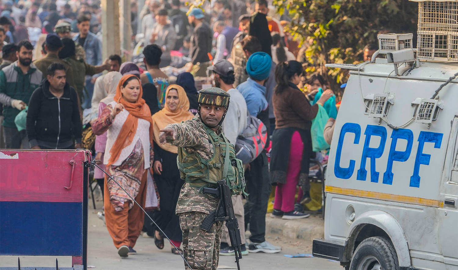 An Indian paramilitary soldiers guards as others inspect the site of a grenade explosion at a marketplace, in Srinagar, Indian controlled Kashmir, on November 3, 2024. (AP)