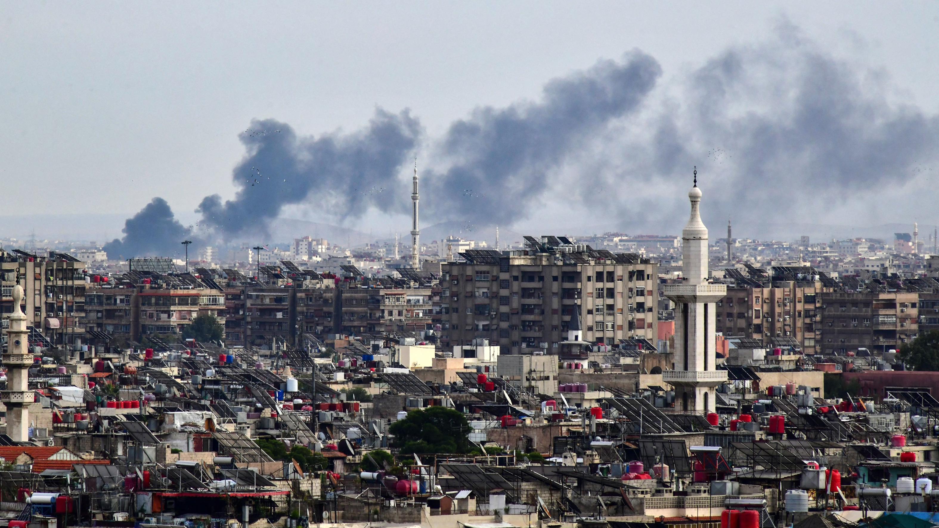 Smoke billows above buildings after an Israeli strike on the outskirts of Damascus on Nov 22, 2023. (File/AFP)