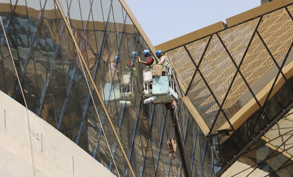 Laborers work on the exterior of the King Abdullah Financial District station of the Riyadh Metro on April 1, 2021. (AFP)