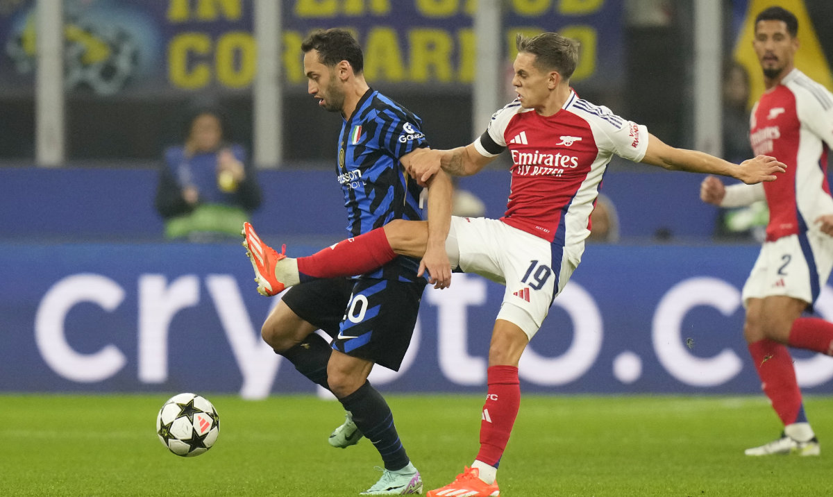 Inter Milan's Hakan Calhanoglu, left, challenges for the ball with Arsenal's Leandro Trossard during a Champions League opening phase soccer match between Inter Milan and Arsenal at the San Siro stadium in Milan, Italy, Wednesday, Nov. 6, 2024. (AP)
