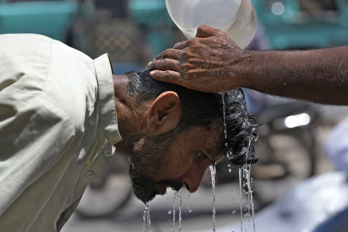 A volunteer pours water to cool a man off during a hot day in Karachi, Pakistan, on May 21, 2024. (AP/File)