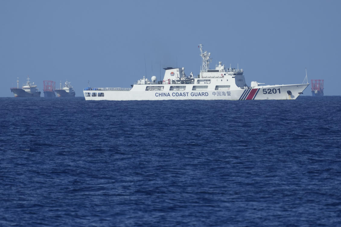 Above, a Chinese coast guard vessel stays beside suspected Chinese militia ships near Thitu island, locally called Pag-asa island on Nov. 6, 2024. China asserts its claim of sovereignty over almost the entire South China Sea through an armada of coast guard ships. (AP)