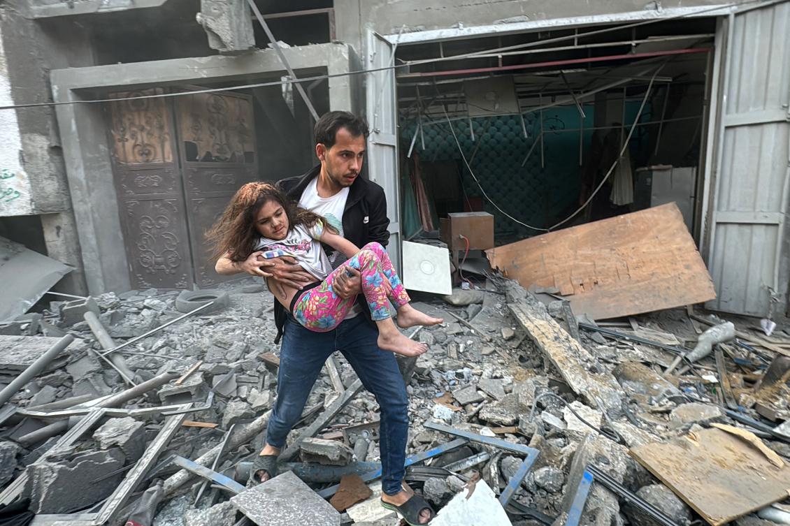 A Palestinian man carries away an injured child from a home that was hit in an Israeli strike on the Jabalia refugee camp in the northern Gaza Strip, on Nov. 7, 2024. (AFP)