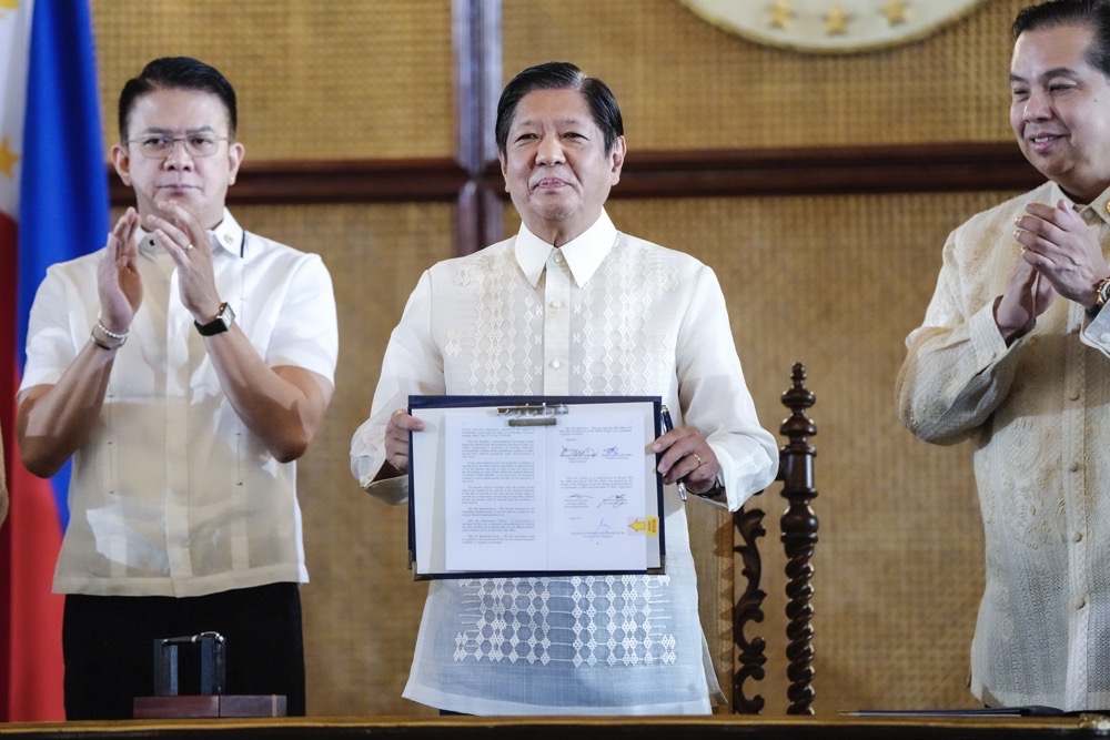 Philippine President Ferdinand Marcos Jr. holds a document during the ceremonial signing of the Philippine Maritime Zones and Philippine Archipelagic Sea Lanes Act. (Malacanang Presidential Communications Office/AP)